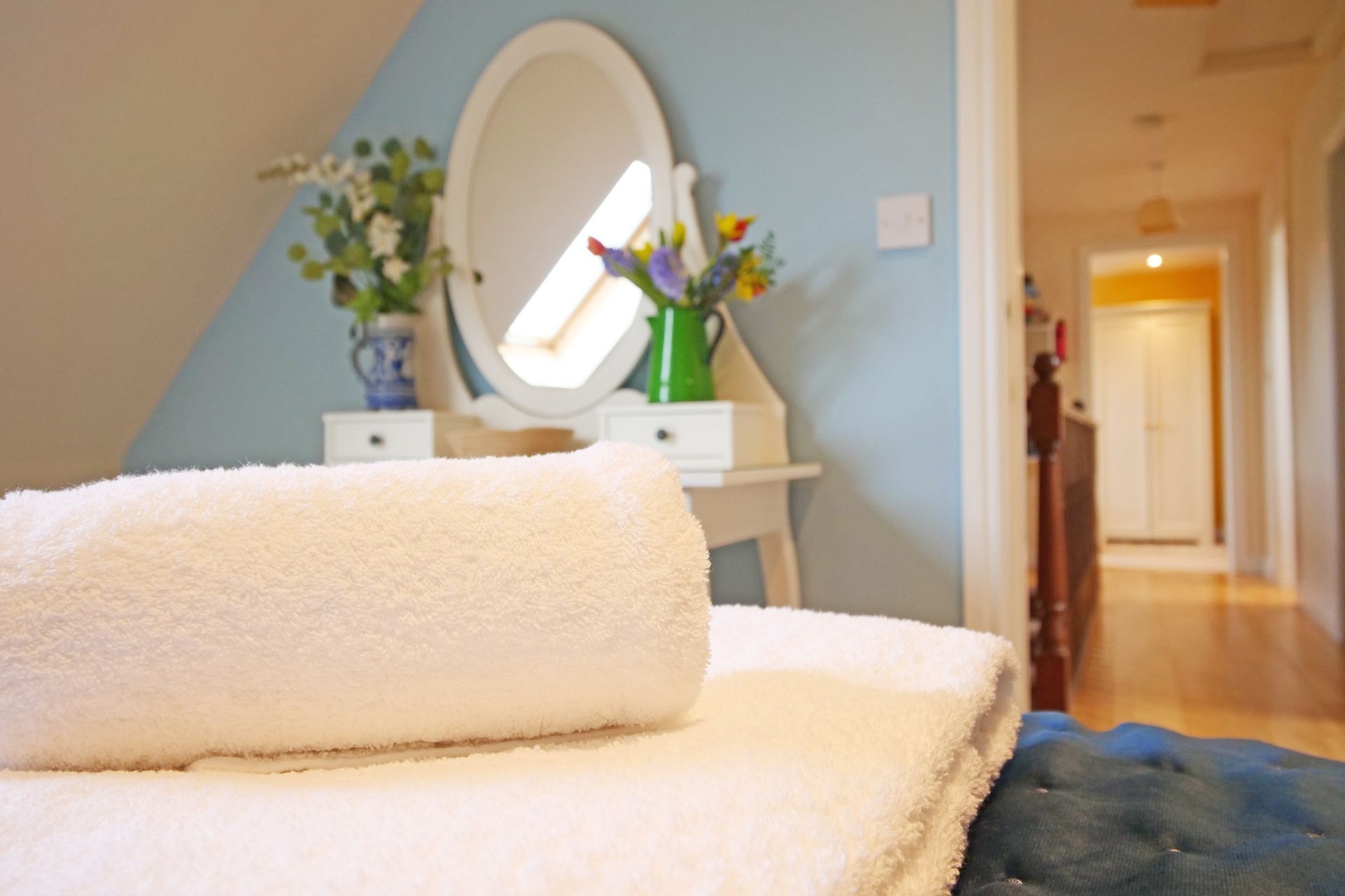 A bed with a mirror and a vase of flowers on it