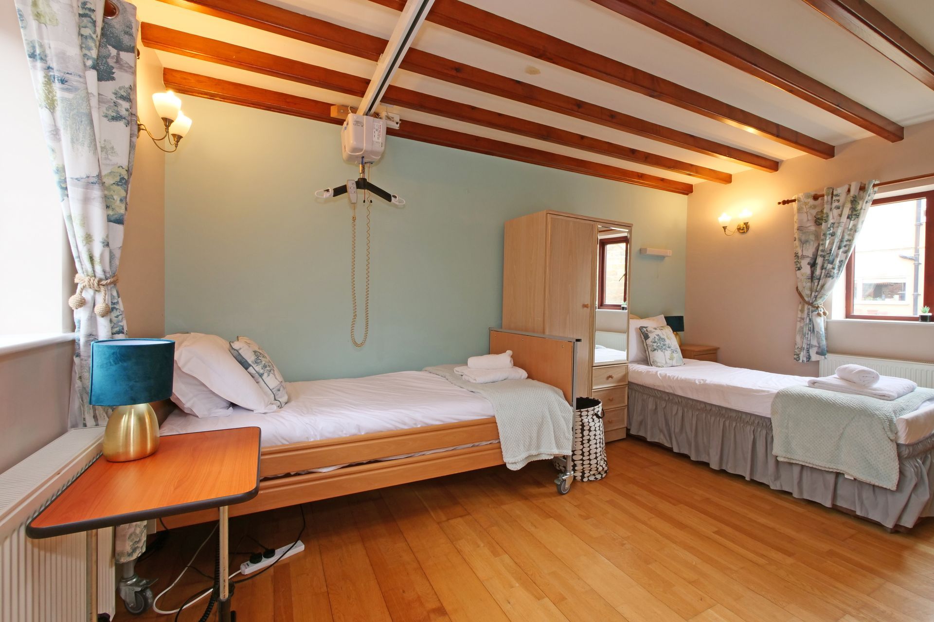 A bedroom with two beds and a table.