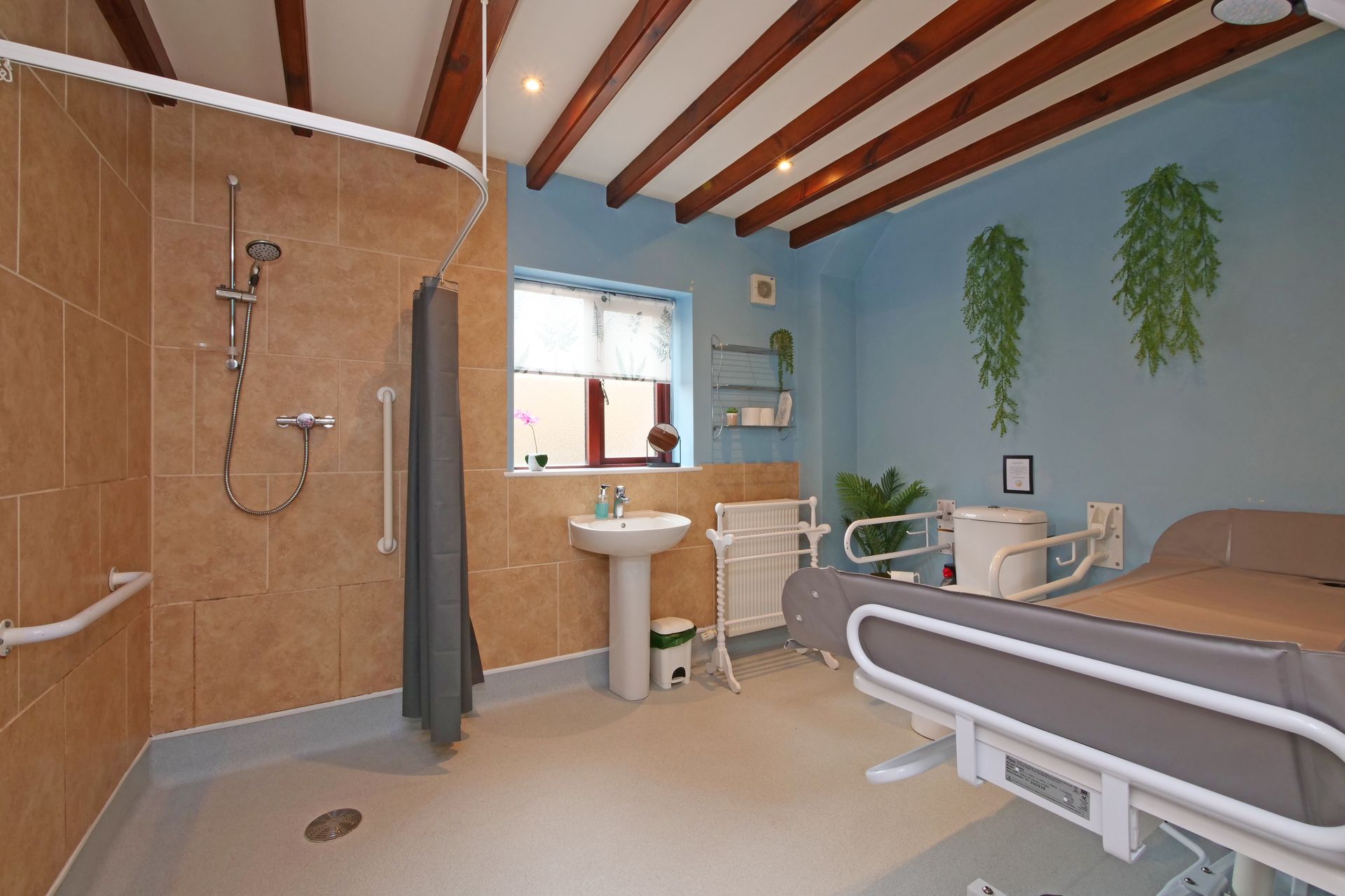 A bathroom with a bed , sink , and shower.