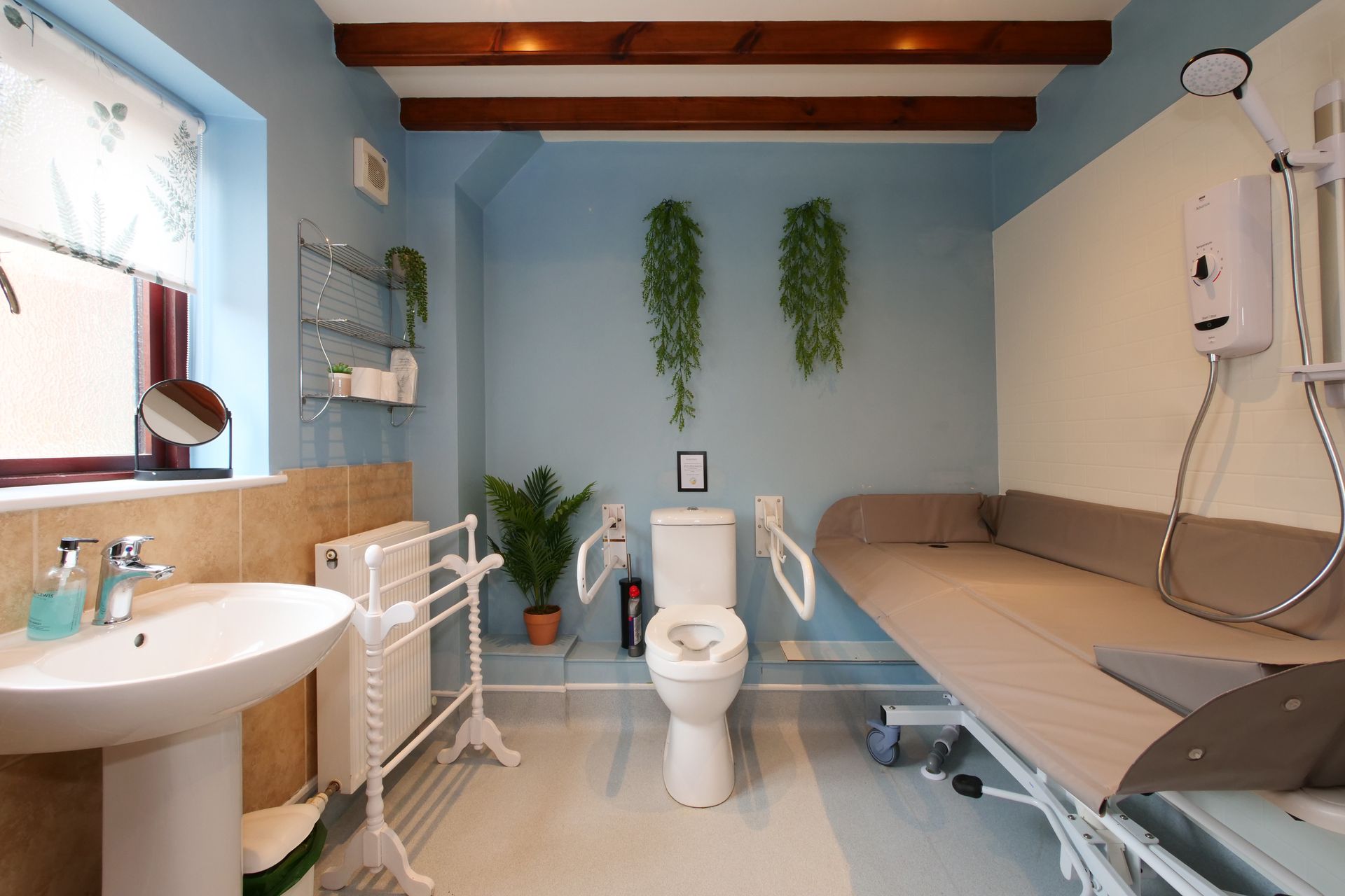 A bathroom with a toilet a sink and a bed
