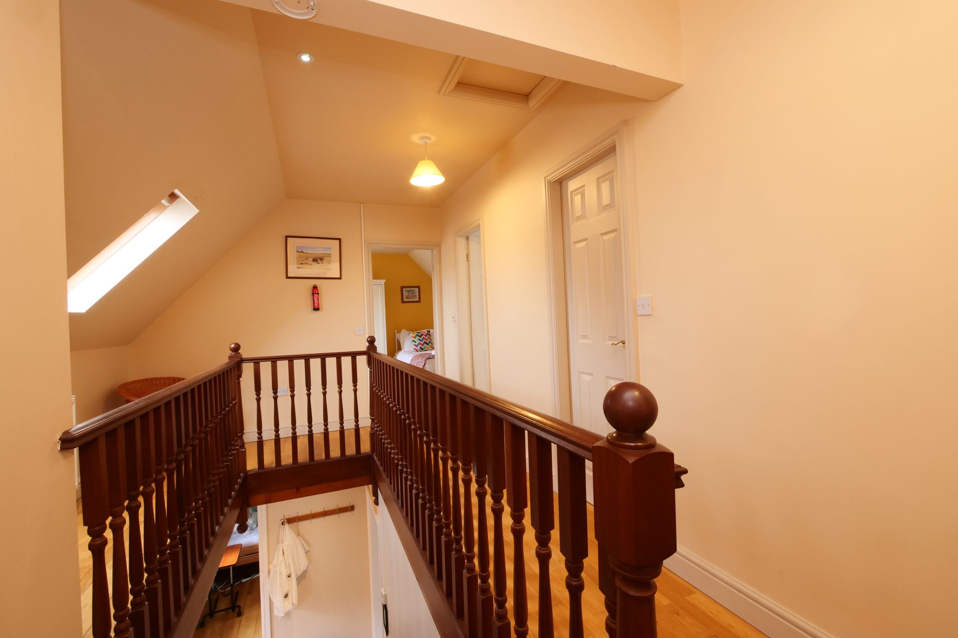 A staircase with a wooden railing leading up to the second floor of a house.