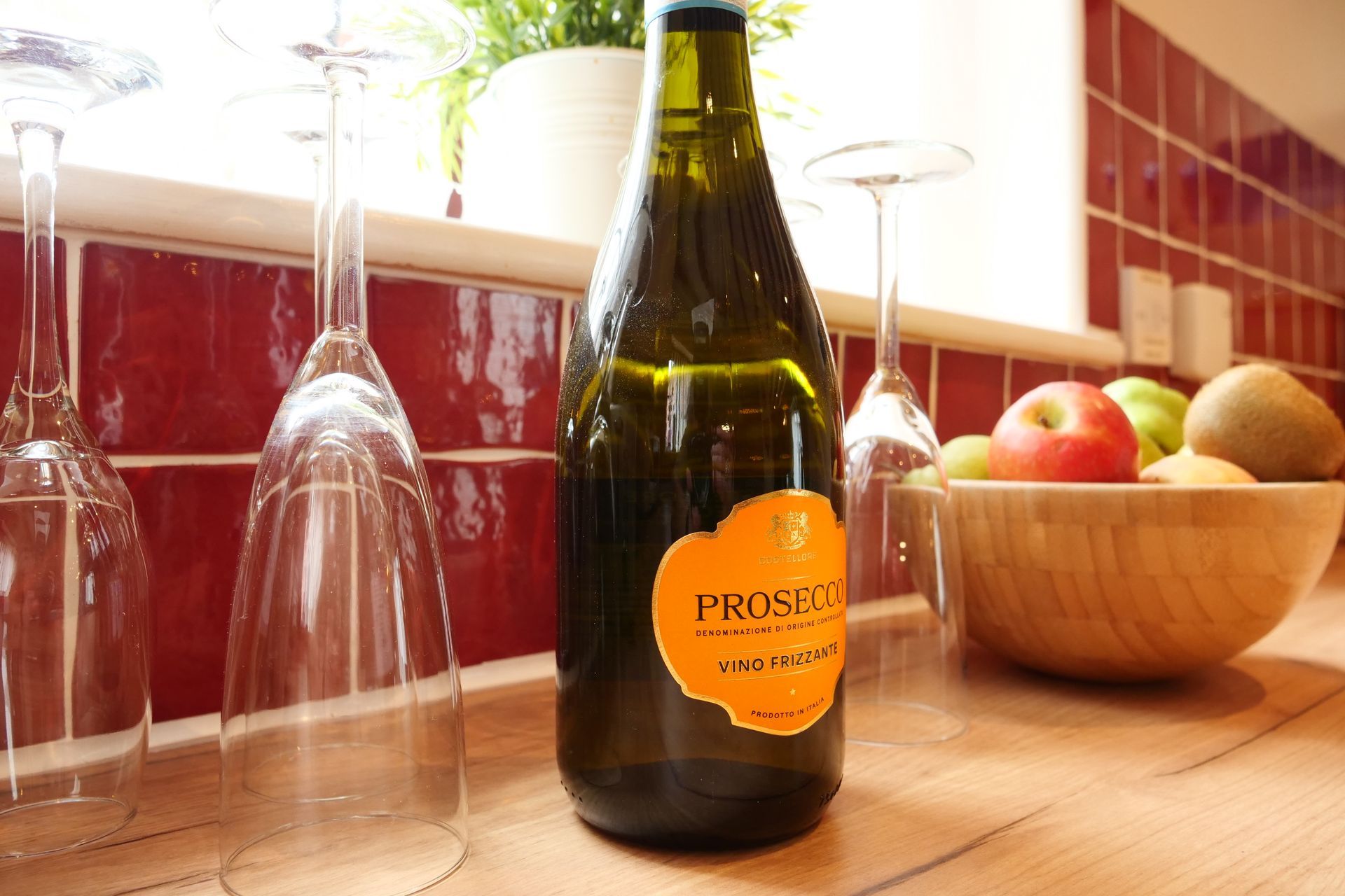 A bottle of prosecco sits on a kitchen counter