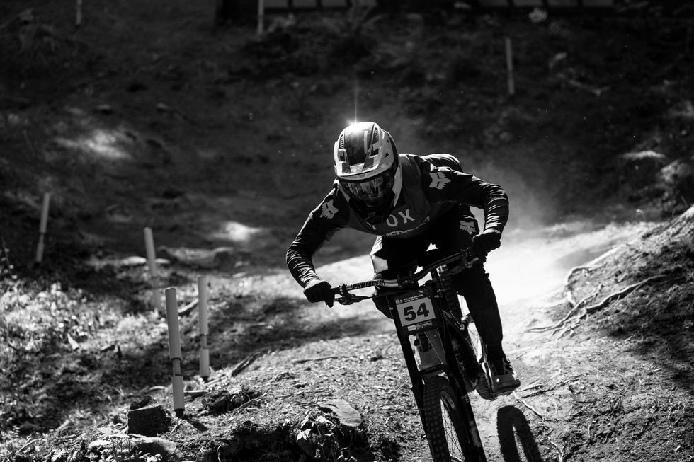 A man is riding a mountain bike down a dirt road.