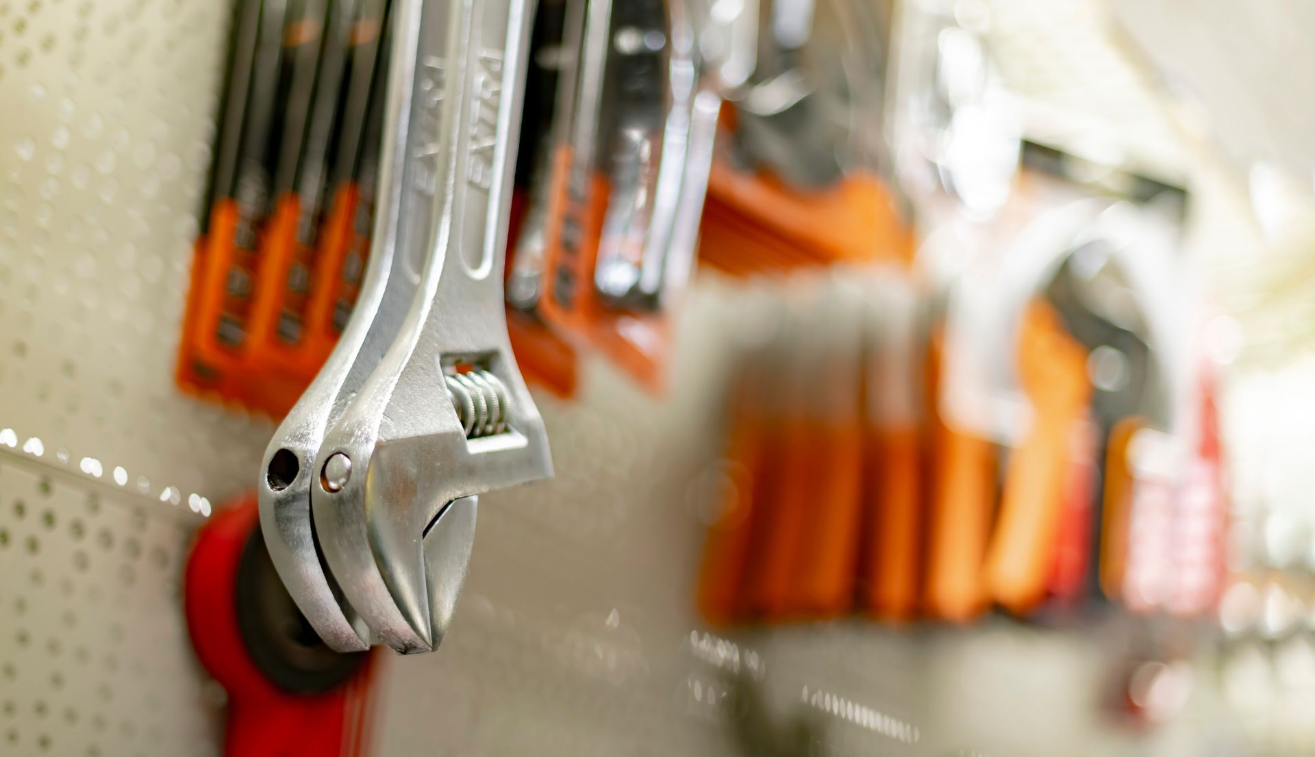 Un primer plano de una llave inglesa colgada en la pared de una tienda.
