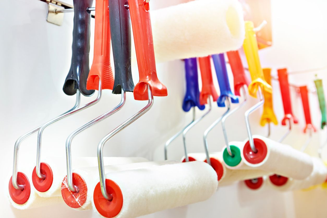 Un montón de rodillos de pintura colgados en una pared.