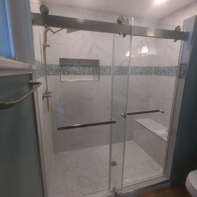 A bathroom with a sliding glass shower door and a toilet.