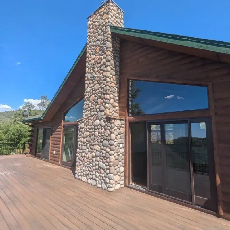 A log cabin with a large stone chimney on the side
