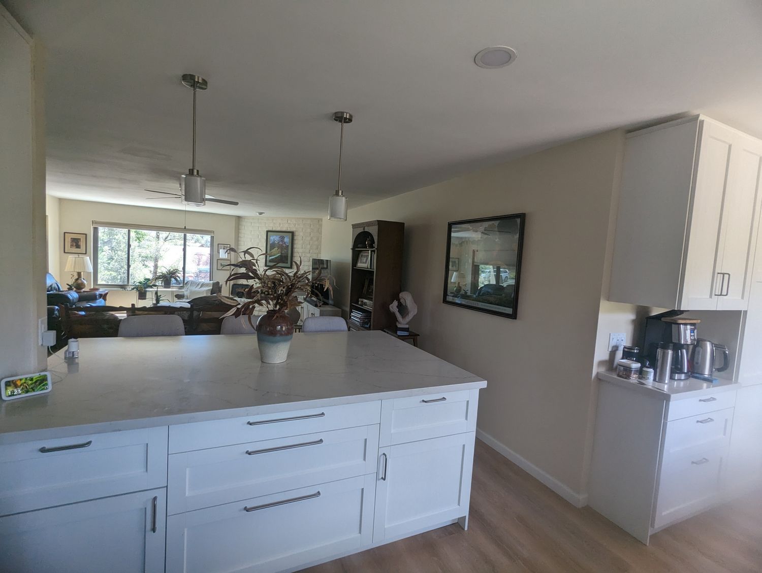 A kitchen with white cabinets and a large island in the middle
