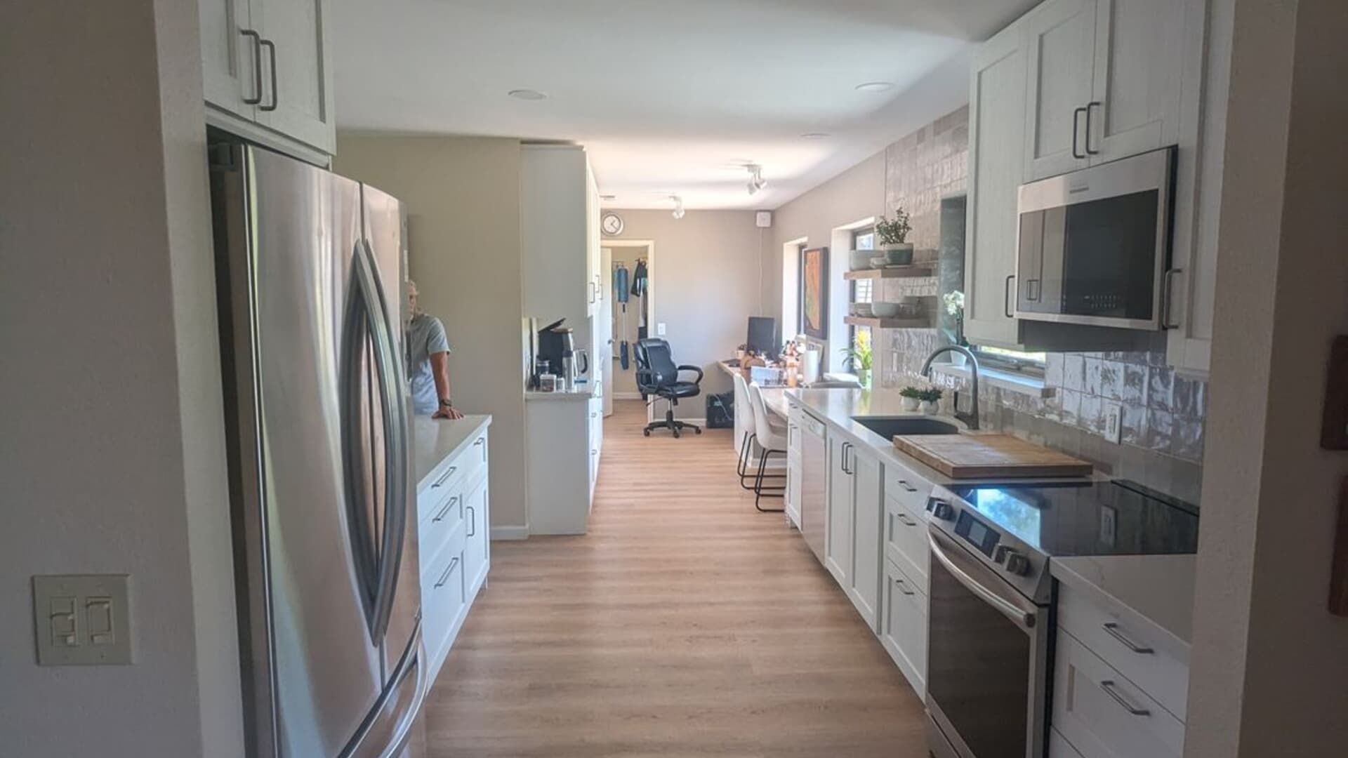 A kitchen with stainless steel appliances and white cabinets.