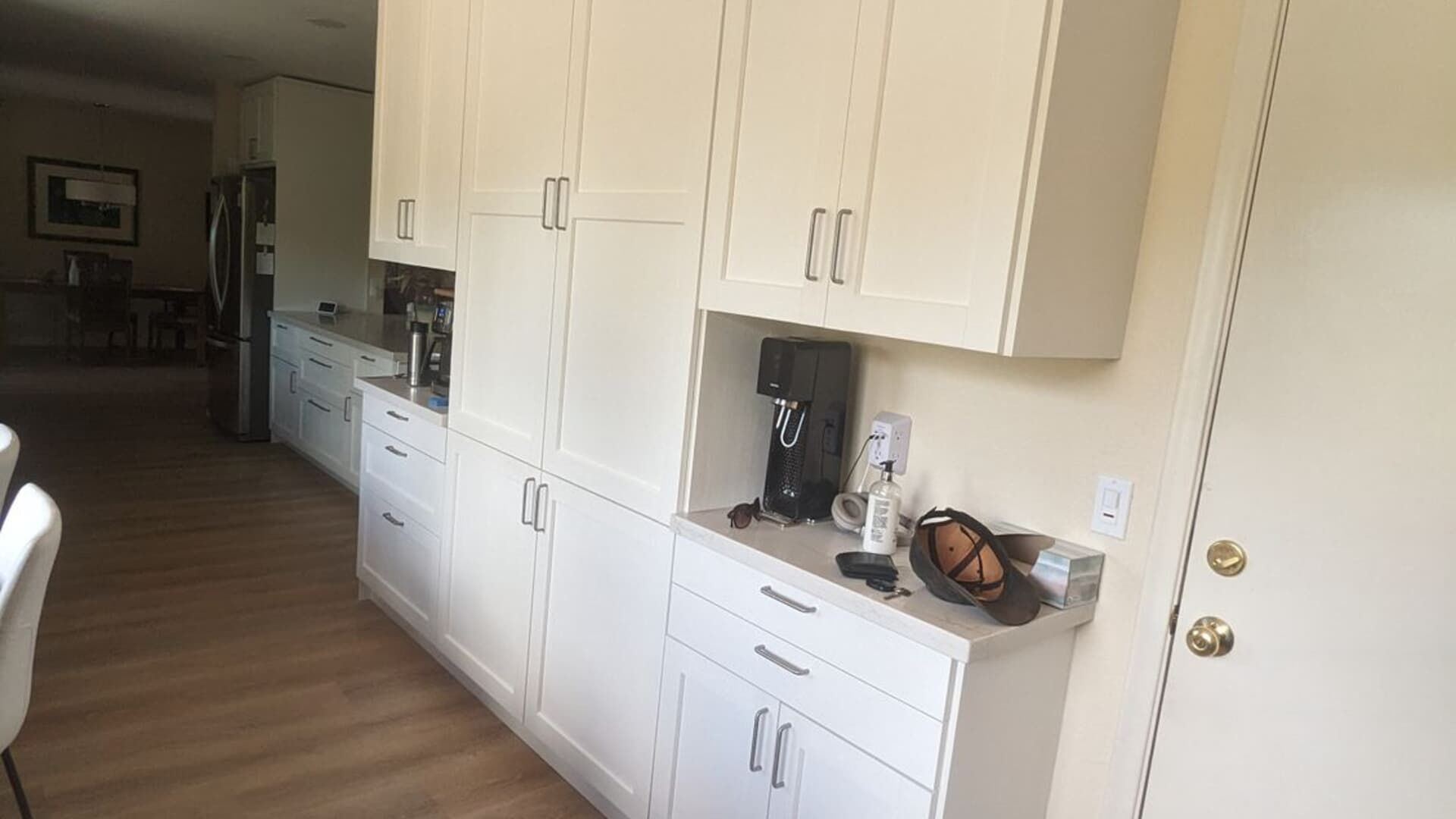 A kitchen with white cabinets and a coffee maker on the counter.