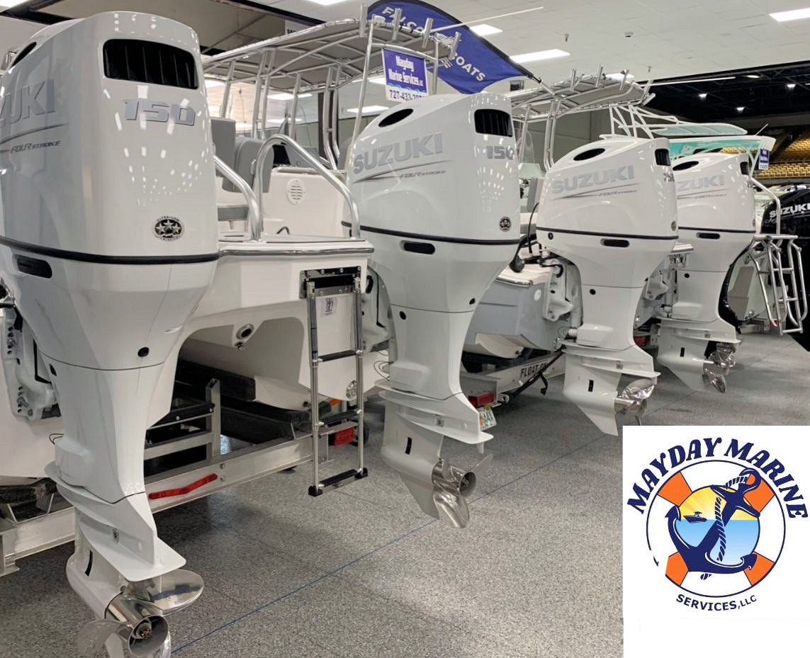 A row of white outboard motors are lined up in a showroom.