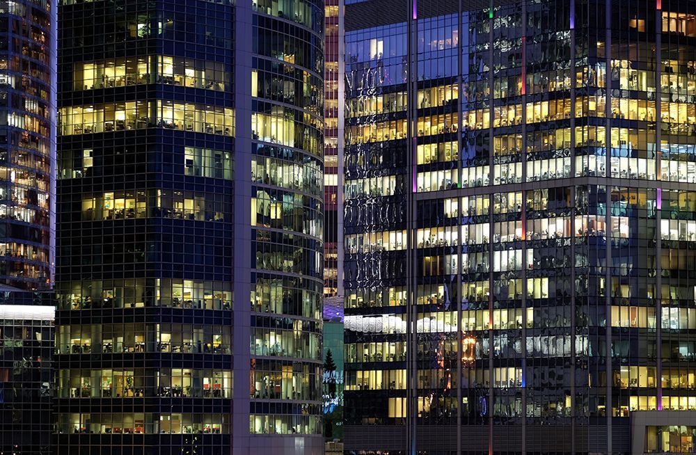 A city skyline at night with a lot of windows lit up