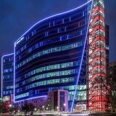 A large building is lit up with blue and red lights