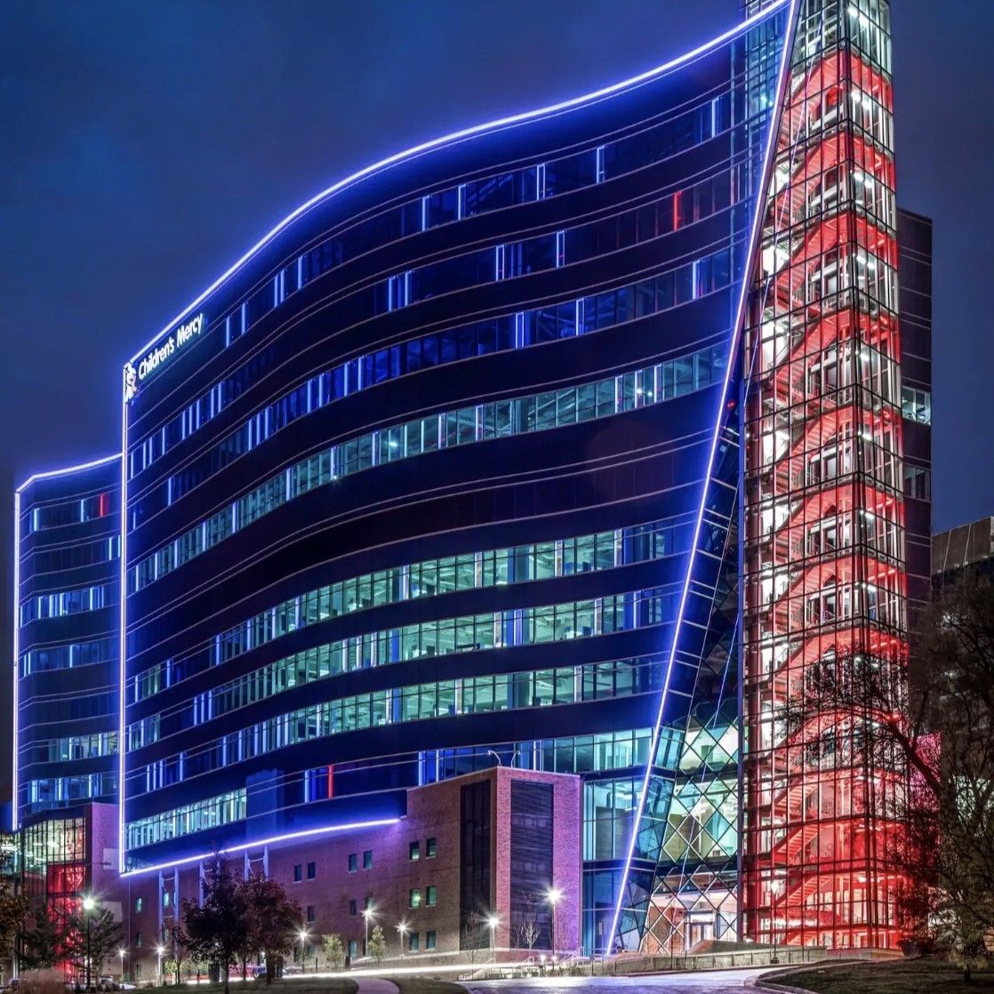 A large building is lit up with blue and red lights