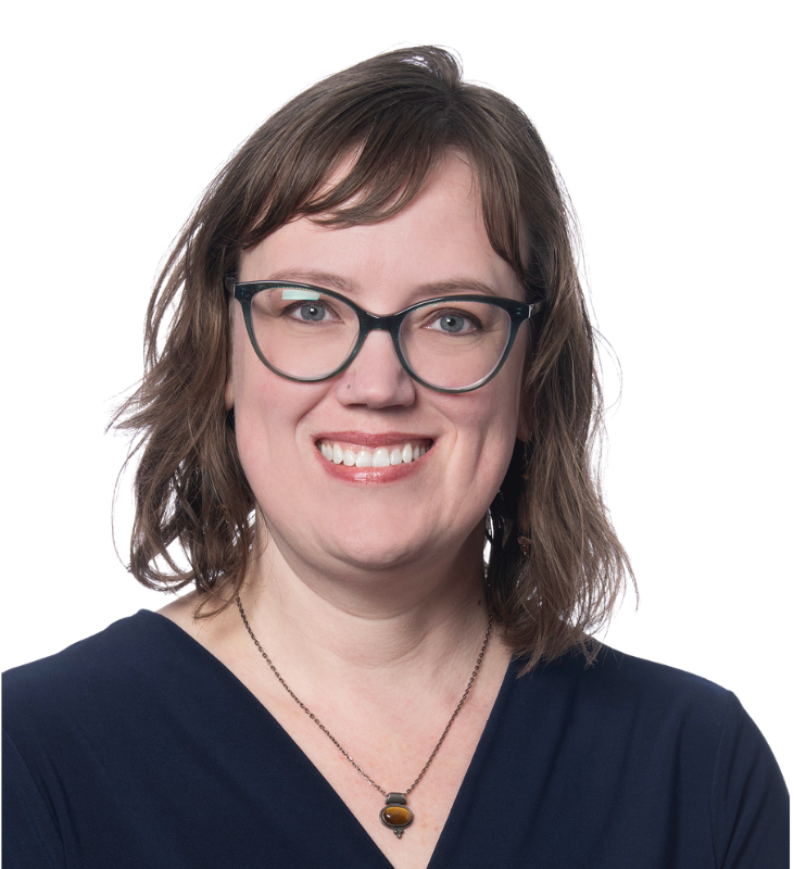 A man with a beard is smiling for the camera while wearing a black shirt.