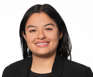 A woman in a black jacket is smiling for the camera