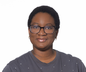 A woman wearing glasses and earrings is smiling for the camera