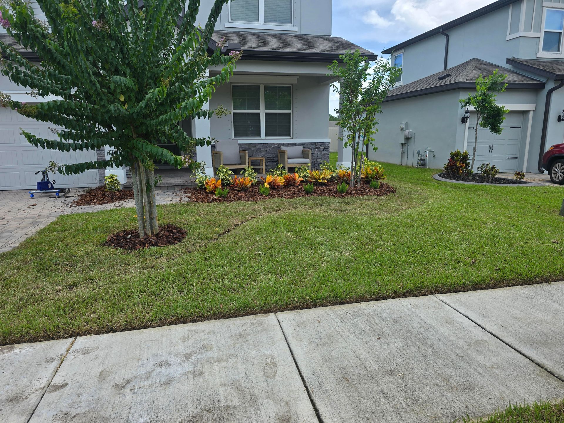 Man kneeling, installing rolled sod on lawn beside a pool.