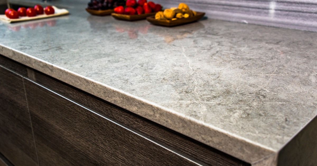 A close-up view of a gray and white granite countertop. There are different types of fruit on the co