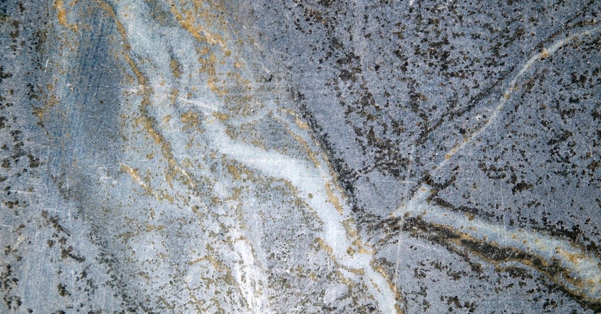Top view of a slab of grey soapstone with beautiful marbling and streaks of gold throughout the pattern.