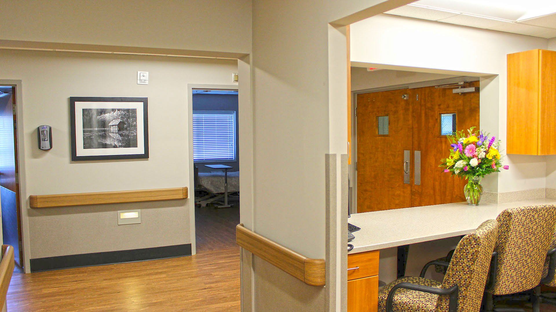 Hallway in facility with doorway, art, and counter.