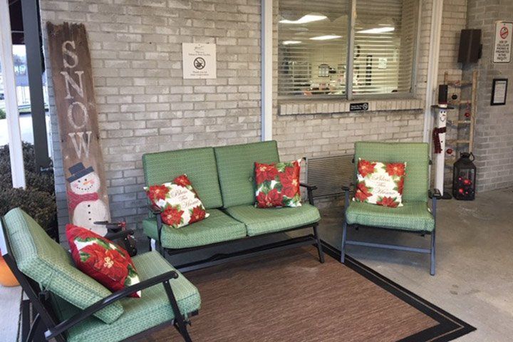 Outdoor seating area with green cushions, festive pillows, and a 