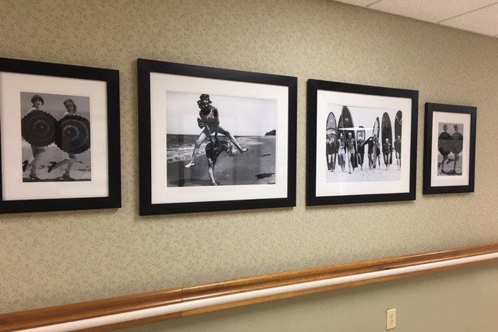 Four framed black and white photos on a beige textured wall.