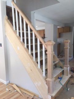A wooden staircase with white railings in a room