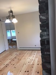 An empty room with a wooden floor and a chandelier