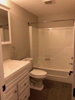 A bathroom with a toilet , sink , and bathtub.
