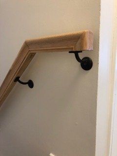 A close up of a wooden handrail on a staircase.
