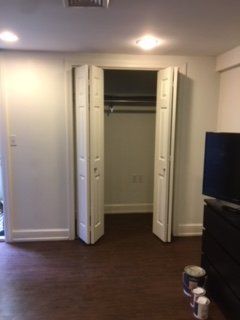 A living room with a closet and a television