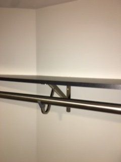 A shelf with a metal rail attached to it