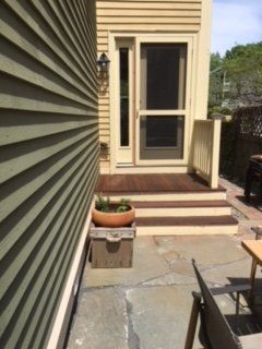A screened in porch with stairs and a potted plant