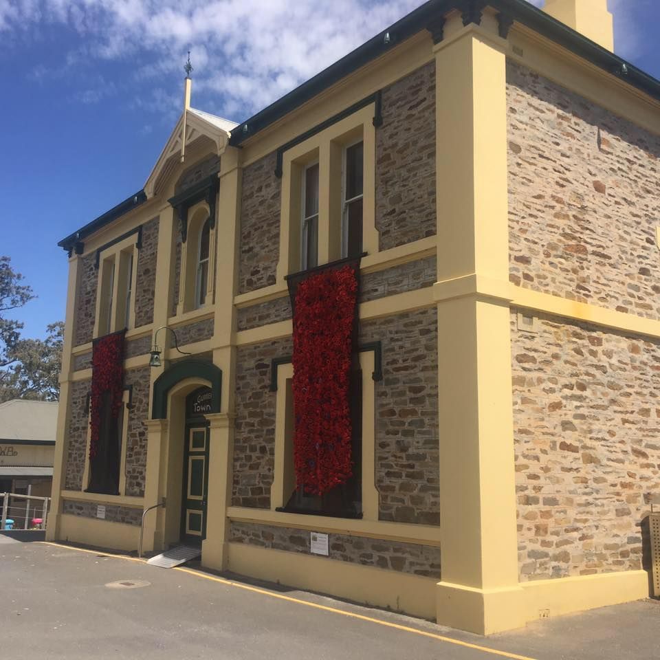 Stone building with red vertical banners; blue sky in the background.