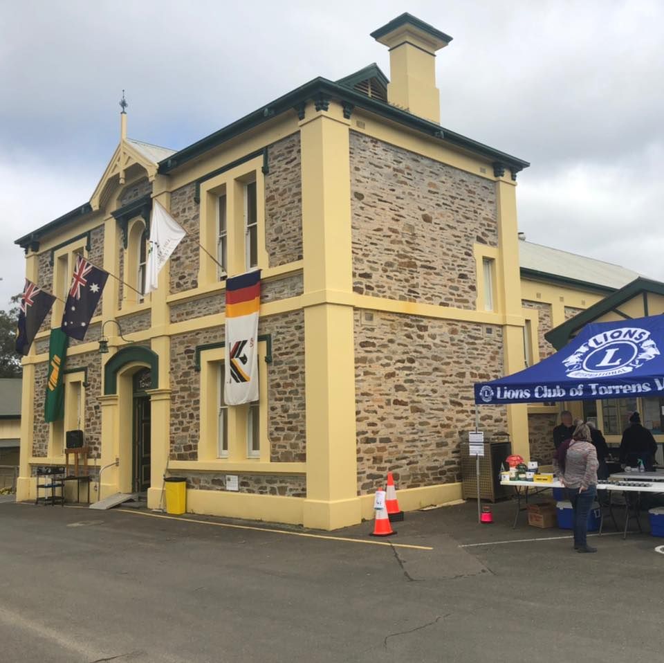 Building with stone facade, flags, and Lions Club tent.
