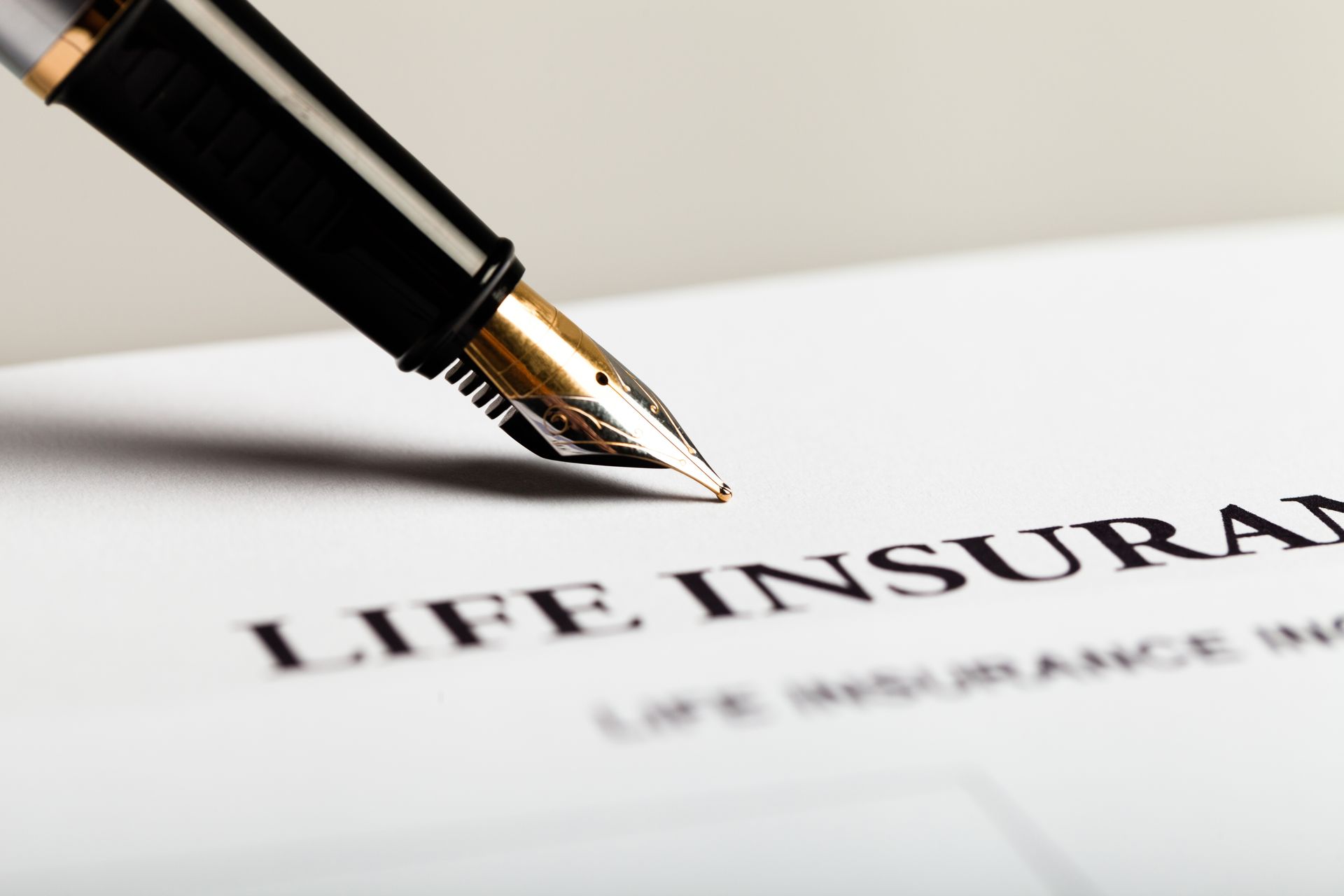 A fountain pen is writing on a piece of paper that says life insurance – Panama City, FL – Harry Grizzle Insurance