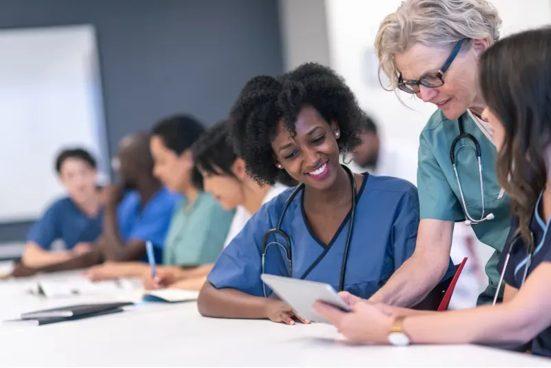 healthcare provider reviewing patient chart, clinician using digital medical record system, aggregated patient medical history dashboard, nationwide medical record integration interface, provider reviewing gaps in care plan, care coordination workflow screen, electronic health record summary view, clinical team discussing patient care, medical data analytics dashboard, coordinated healthcare team meeting