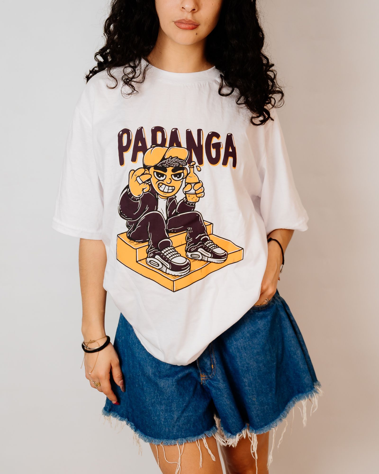 Mujer que lleva una camiseta blanca con un gráfico de dibujos animados y pantalones cortos de mezclilla.