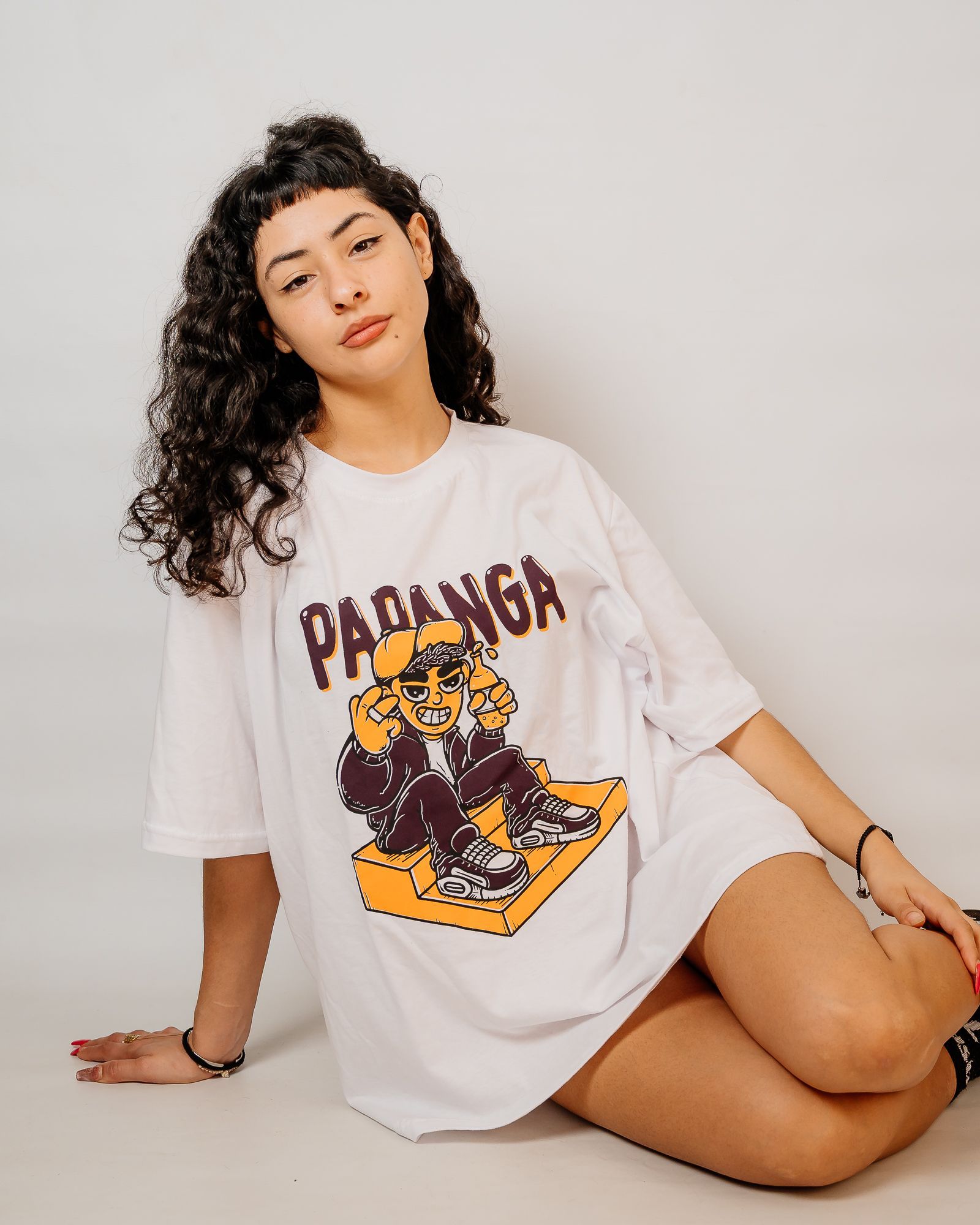 Mujer que lleva una camiseta blanca con un gráfico de dibujos animados y pantalones cortos de mezclilla.
