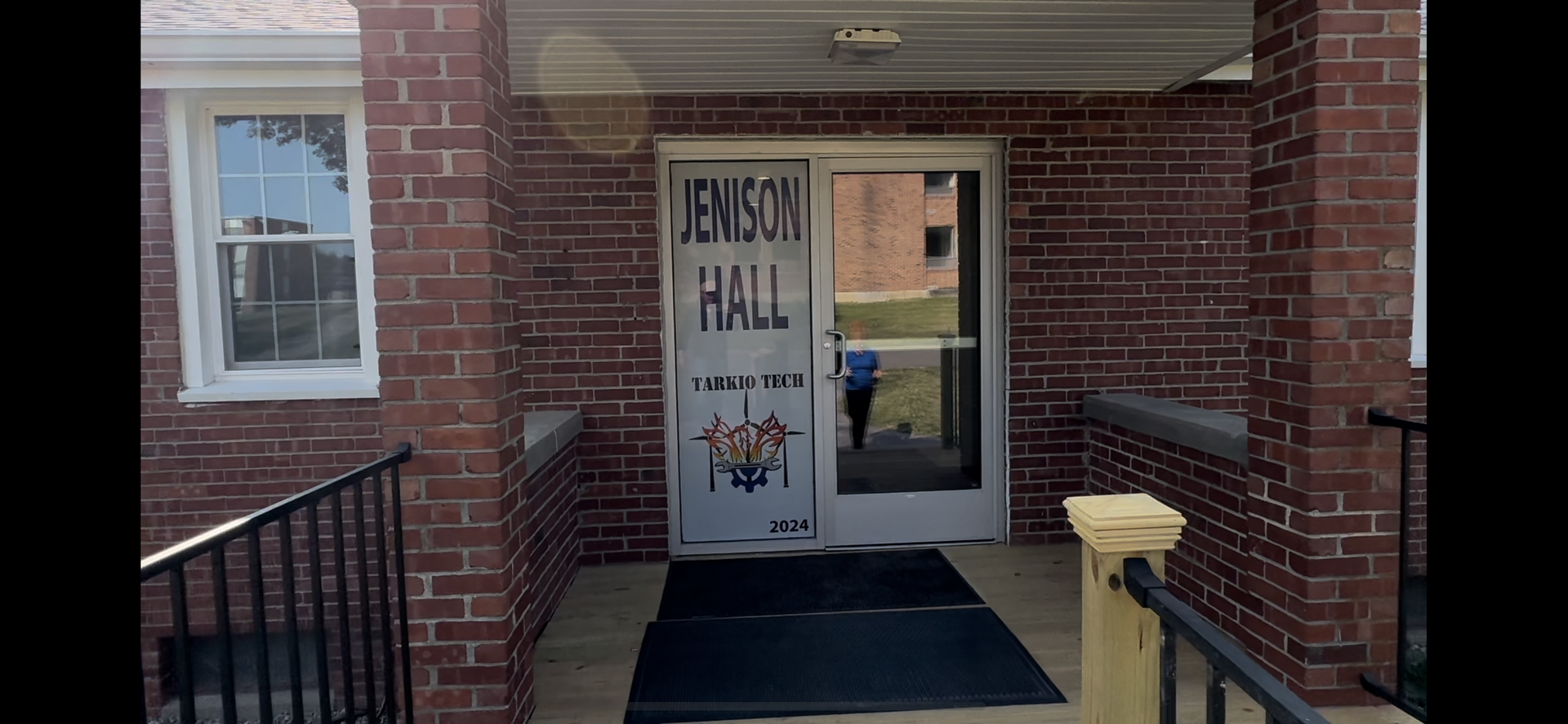 A brick building with a sign on the door that says lenson hall