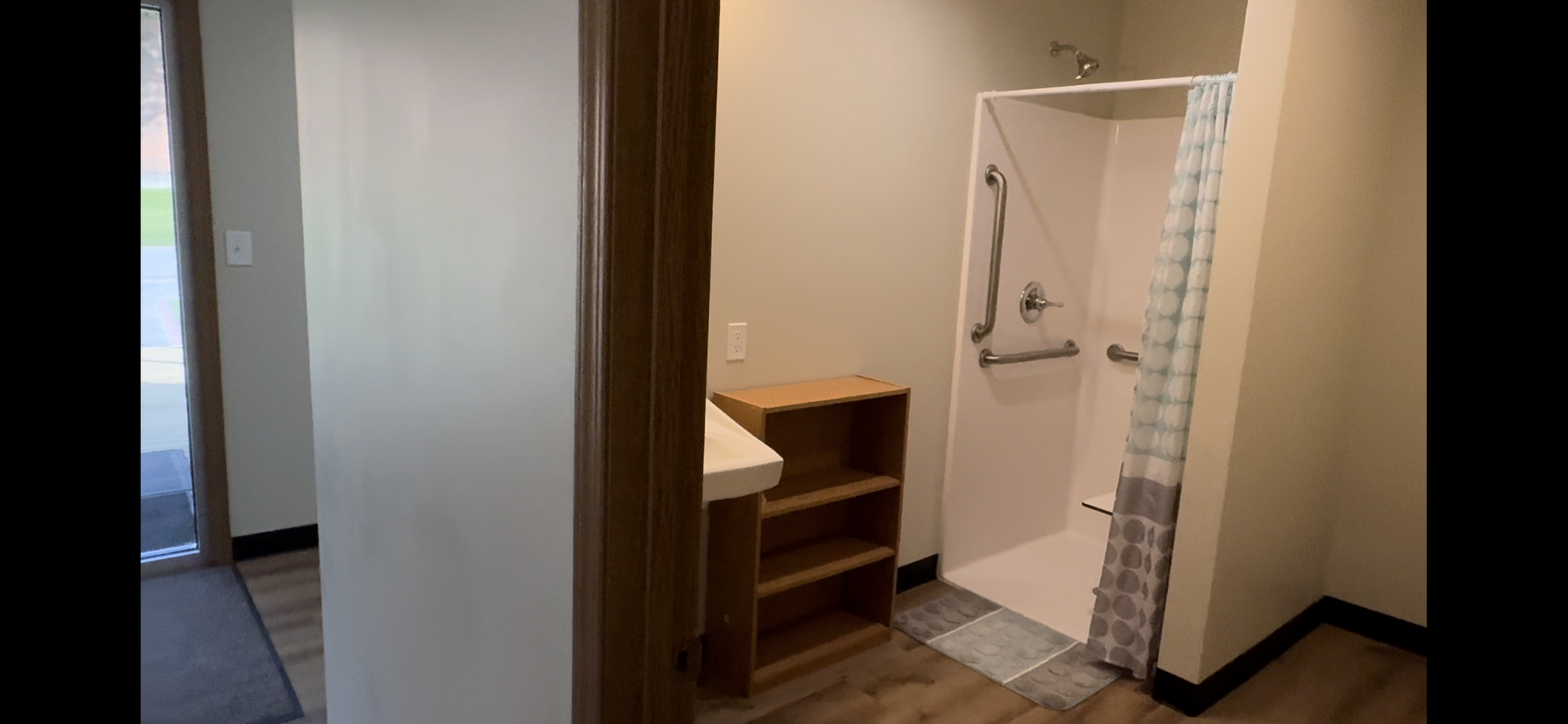 A bathroom with a walk in shower and a sink.