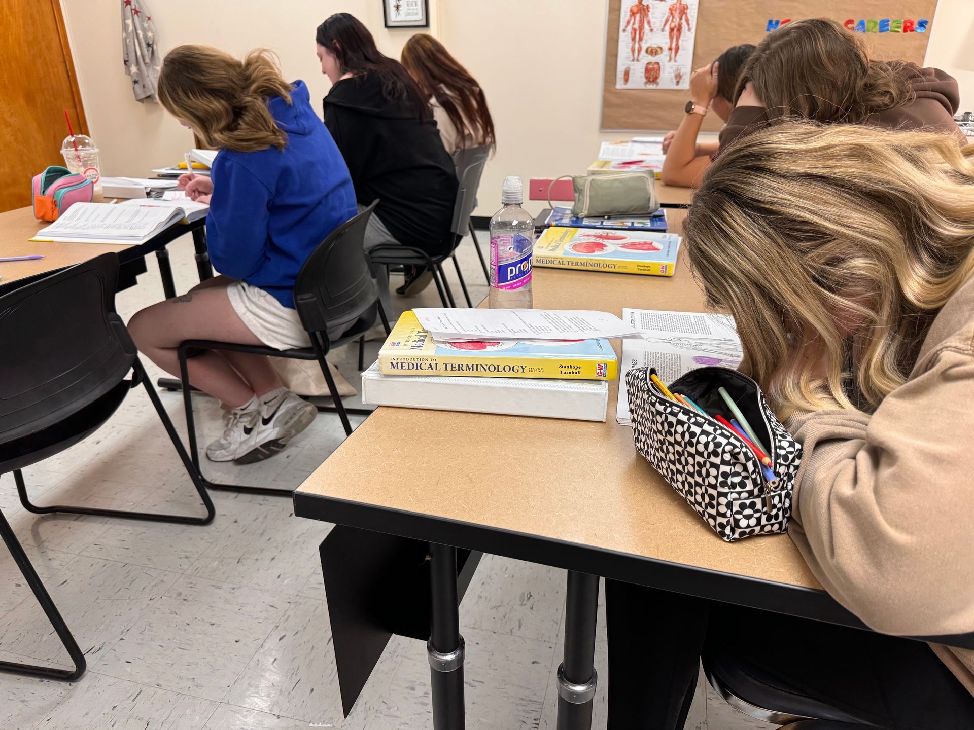 A group of students are sitting at desks in a classroom.
