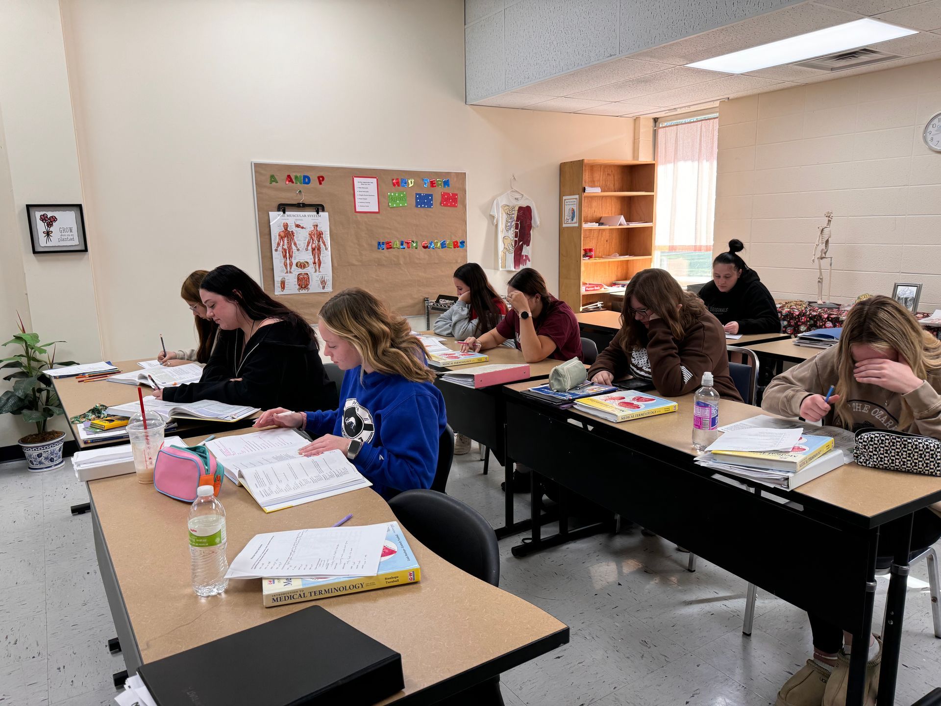 A group of people are sitting at tables in a classroom.