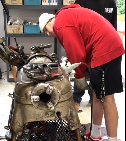 A plumber is fixing a sink pipe with a wrench.