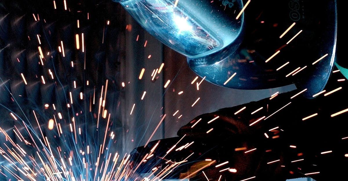 A man is welding a piece of metal with sparks coming out of it.