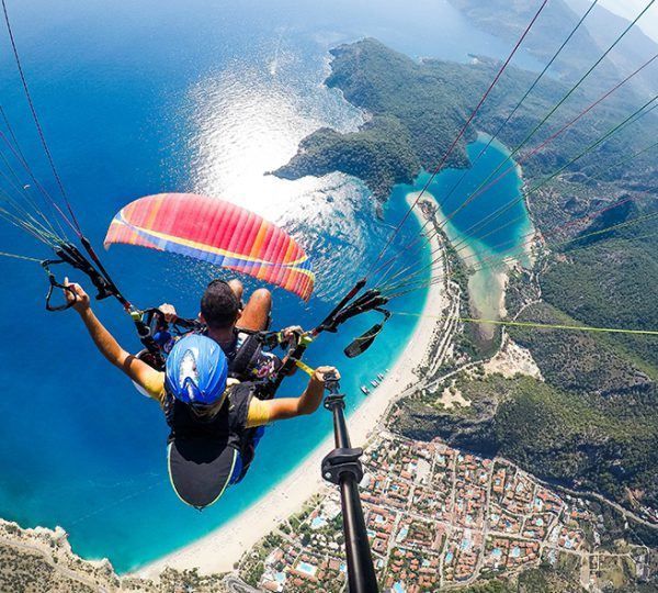 A person is parasailing over a body of water