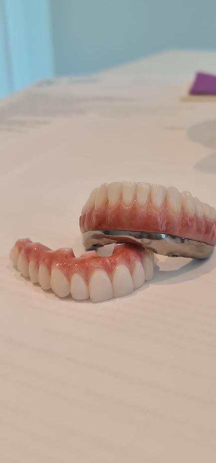 A pair of dentures sitting on top of a white table.