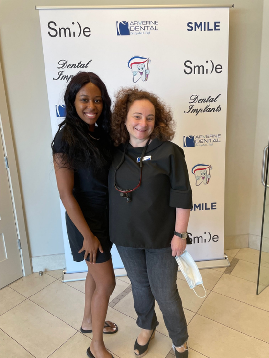 Two women smiling in front of a 