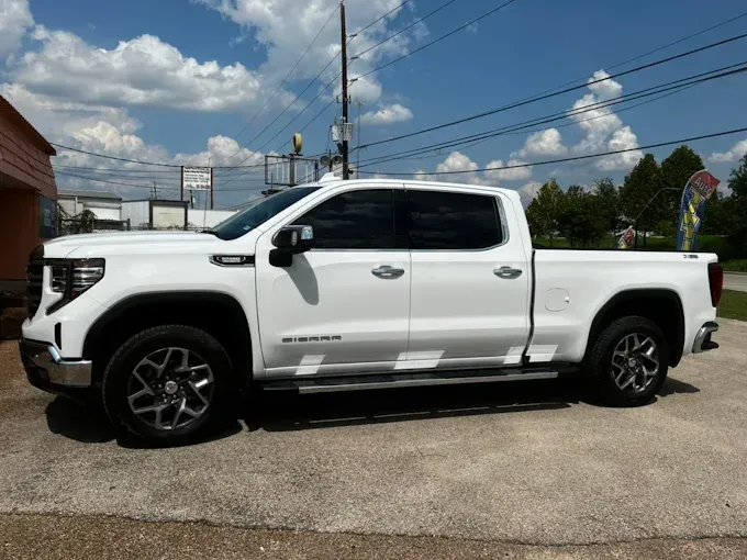 White GMC Sierra truck parked outside on a sunny day.